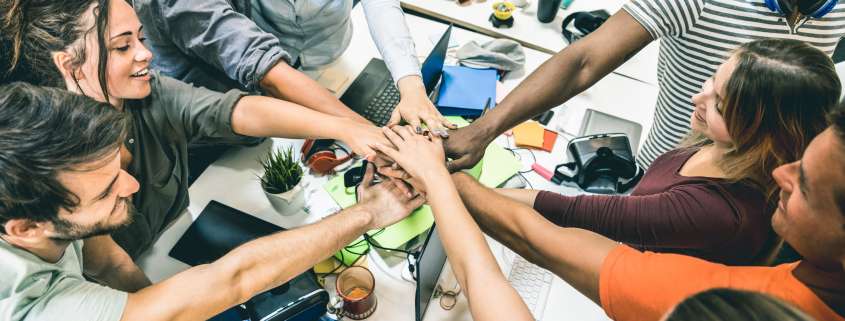 Young employee startup workers group stacking hands at urban stu