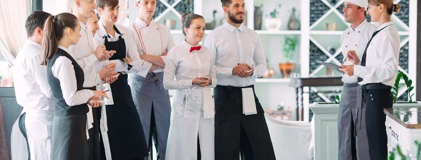 Restaurant manager and his staff in terrace. interacting to head chef in restaurant.
